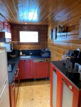 Coin cuisine moderne et lumineux avec plaques électriques, ameublement bois, fenêtre