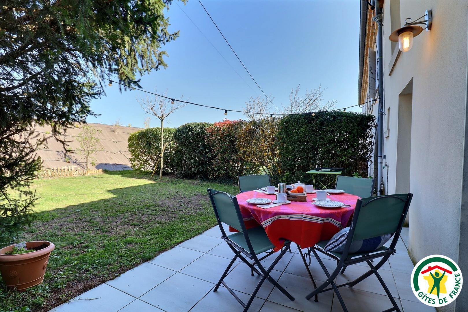 Petit jardin privatif, avec terrasse, table extérieure et plancha.