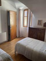 Chambre à coucher lumineuse avec deux lits simples, ameublement bois, fenêtre