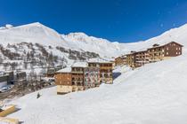 Side view of the residence, a multi-story building, snow around the building and a view of the resort
