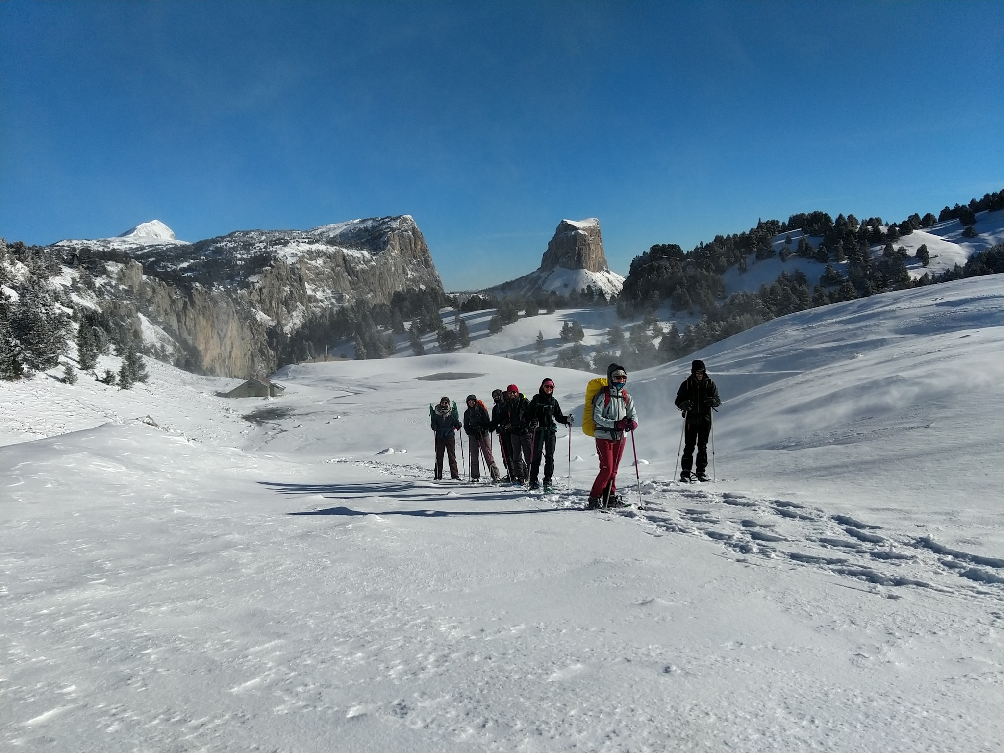 Photo lors d'un hiver d'un groupe de 7 personnes faisant une randonnée dans la neige en raquettes