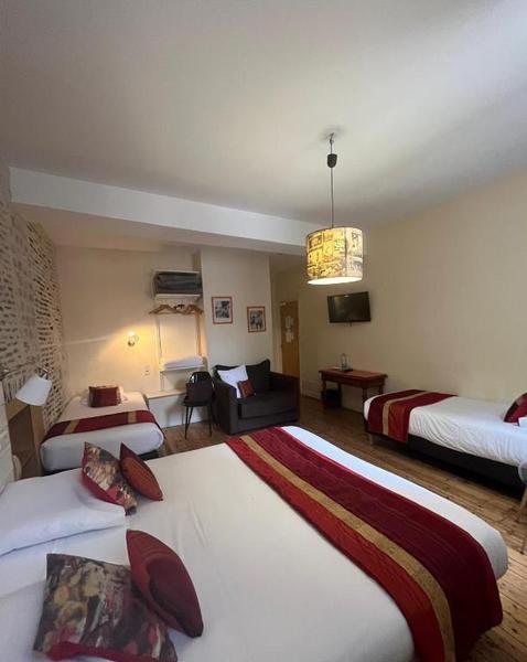 Une chambre quadruple avec un lit double et deux lits simples.